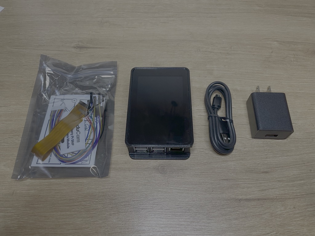 Assembled PiWalletSV Pro with camera module, USB cable, and power adapter